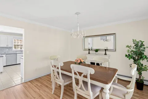 a dining room with furniture a chandelier and wooden floor