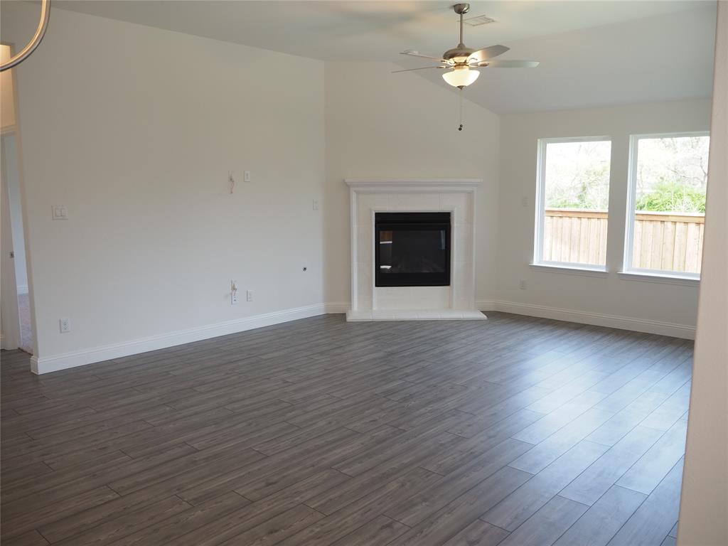 2201 Yellowhammer Road Denton, TX 76205 - Photo 11 of 36 an empty room with wooden floor ceiling fan and windows