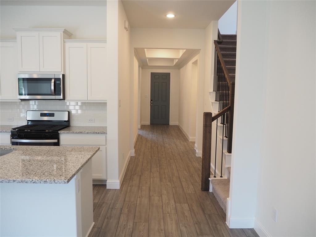 2201 Yellowhammer Road Denton, TX 76205 - Photo 12 of 36 a kitchen with granite countertop a refrigerator and a stove top oven