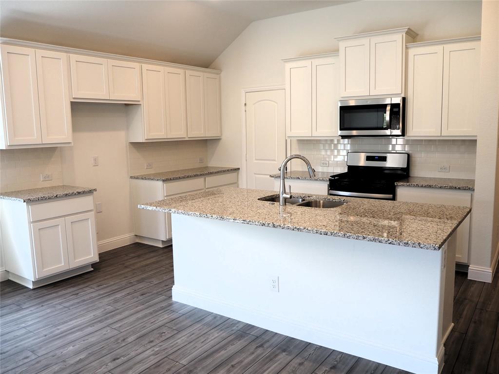 2201 Yellowhammer Road Denton, TX 76205 - Photo 6 of 36 a kitchen with granite countertop a sink and a stove top oven