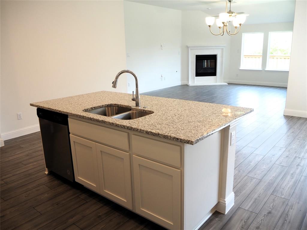 2201 Yellowhammer Road Denton, TX 76205 - Photo 8 of 36 a kitchen with stainless steel appliances granite countertop a sink dishwasher and microwave with wooden floor