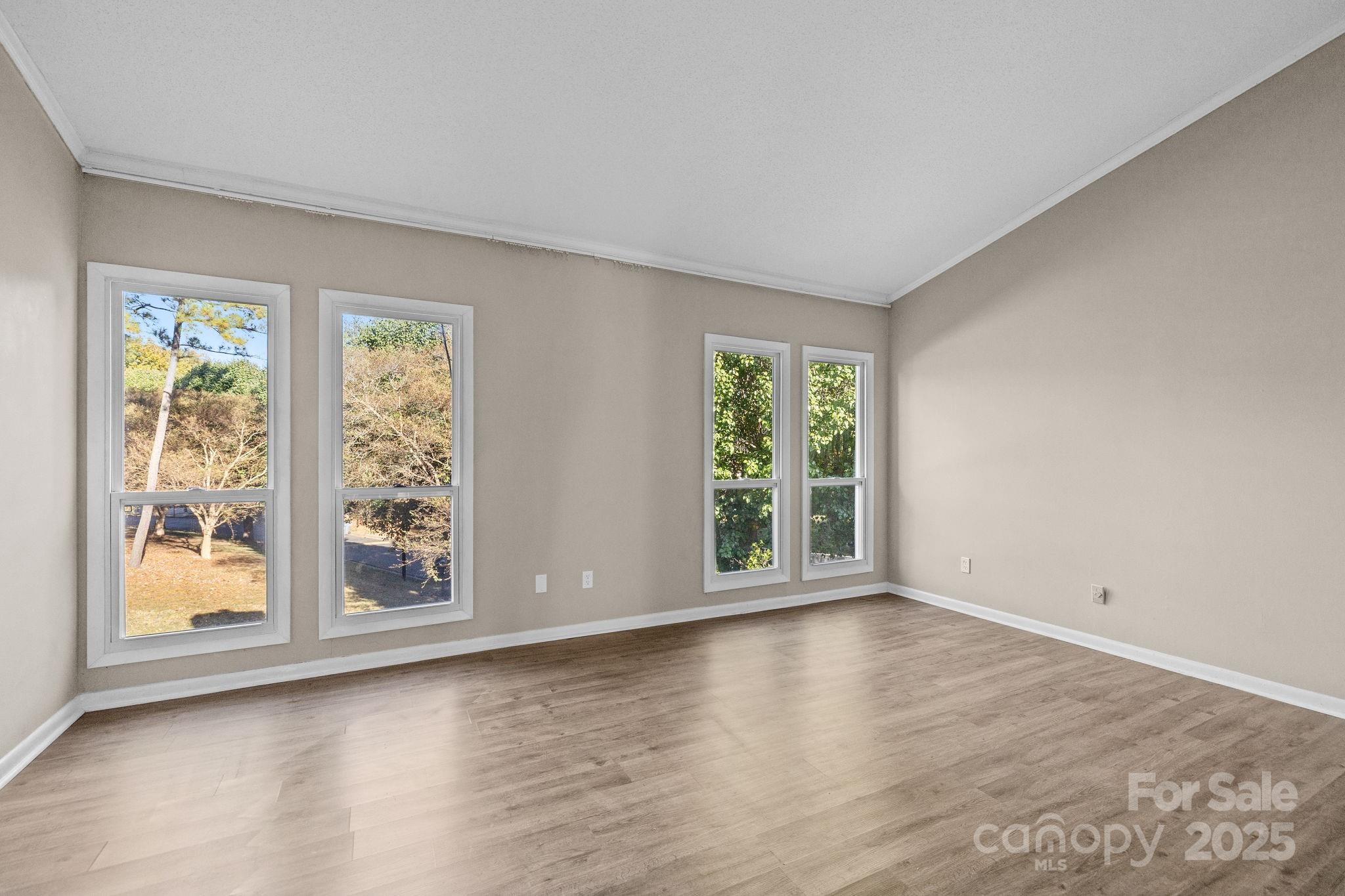 7939 Charter Oak Lane Charlotte, NC 28226 - Photo 17 of 28 a view of an empty room with wooden floor and a window