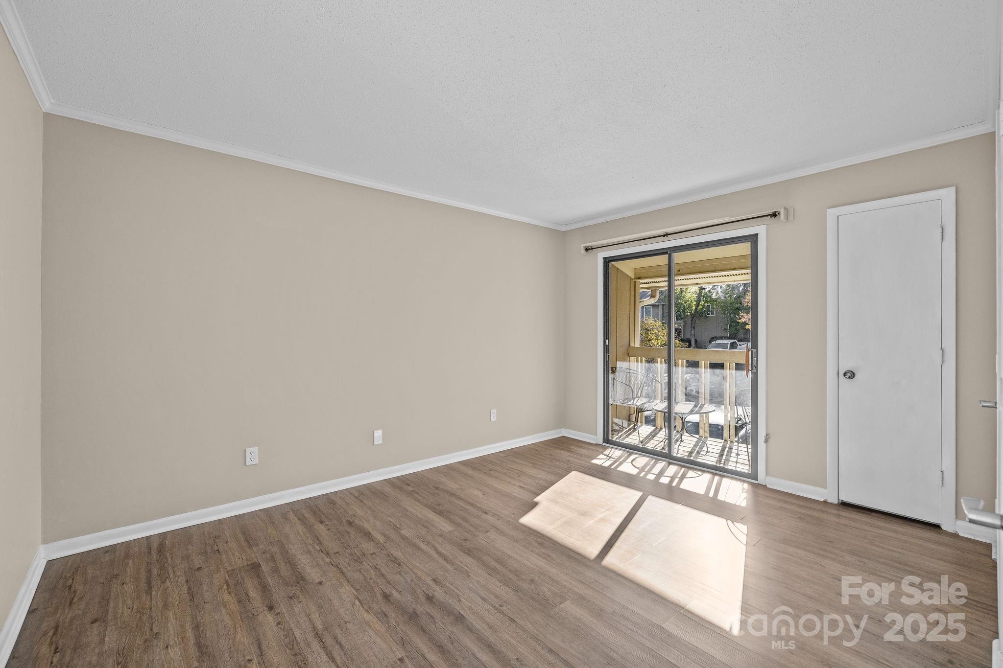 7939 Charter Oak Lane Charlotte, NC 28226 - Photo 21 of 28 wooden floor in an empty room with a window