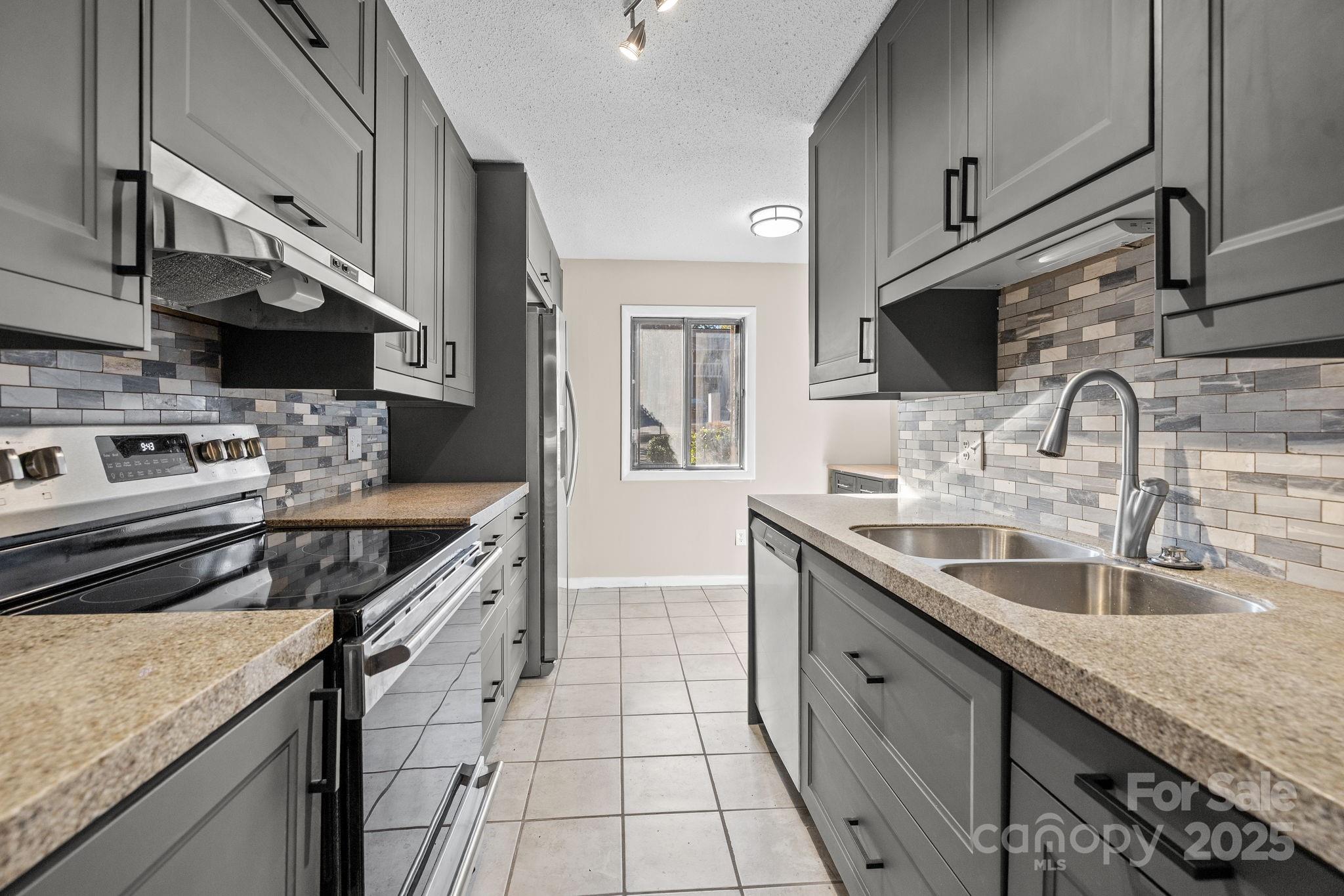 7939 Charter Oak Lane Charlotte, NC 28226 - Photo 6 of 28 a kitchen with stainless steel appliances granite countertop a sink stove and cabinets