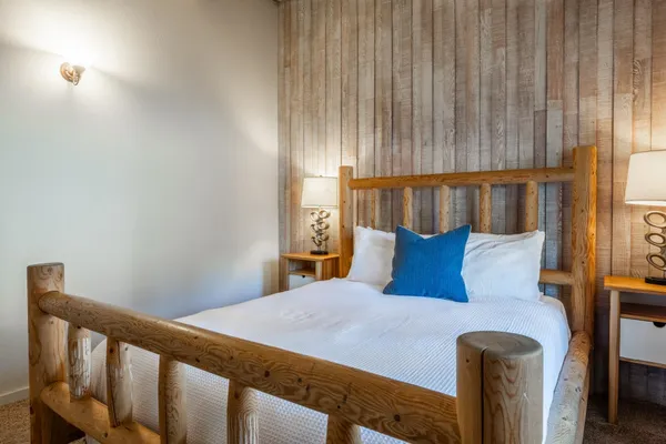 a large bed in a bedroom next to a window