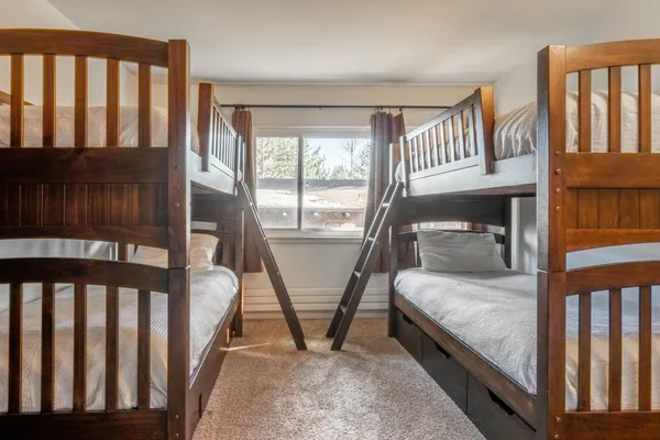a bedroom with two beds and a large window