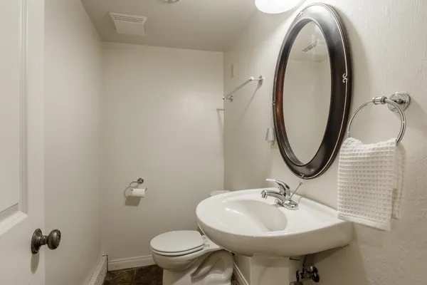 a bathroom with a sink a toilet and mirror