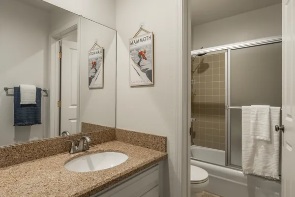 a bathroom with a granite countertop sink toilet and shower