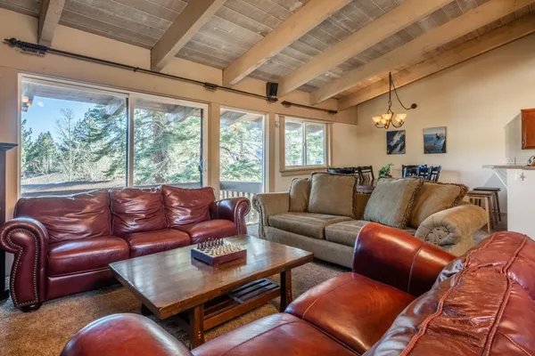 a living room with furniture a ceiling fan and a large window