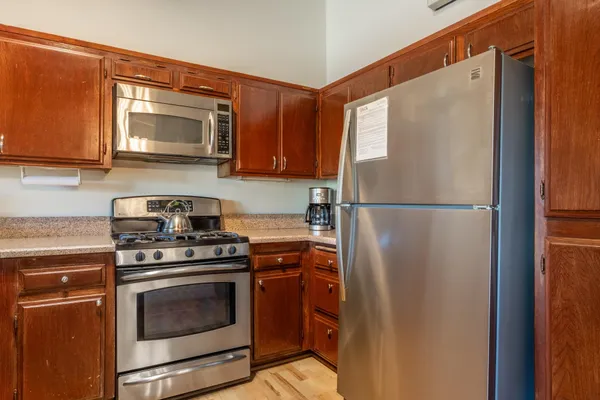 a kitchen with stainless steel appliances granite countertop a refrigerator stove and microwave