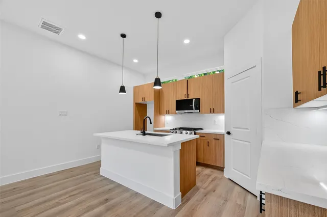 a kitchen with a sink a faucet a stove and a refrigerator