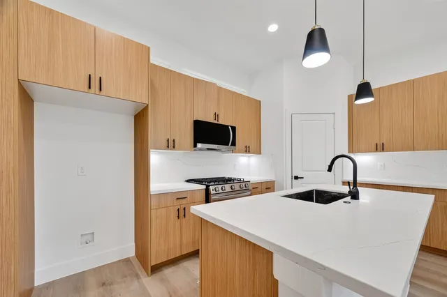 a kitchen with a sink a stove and cabinets