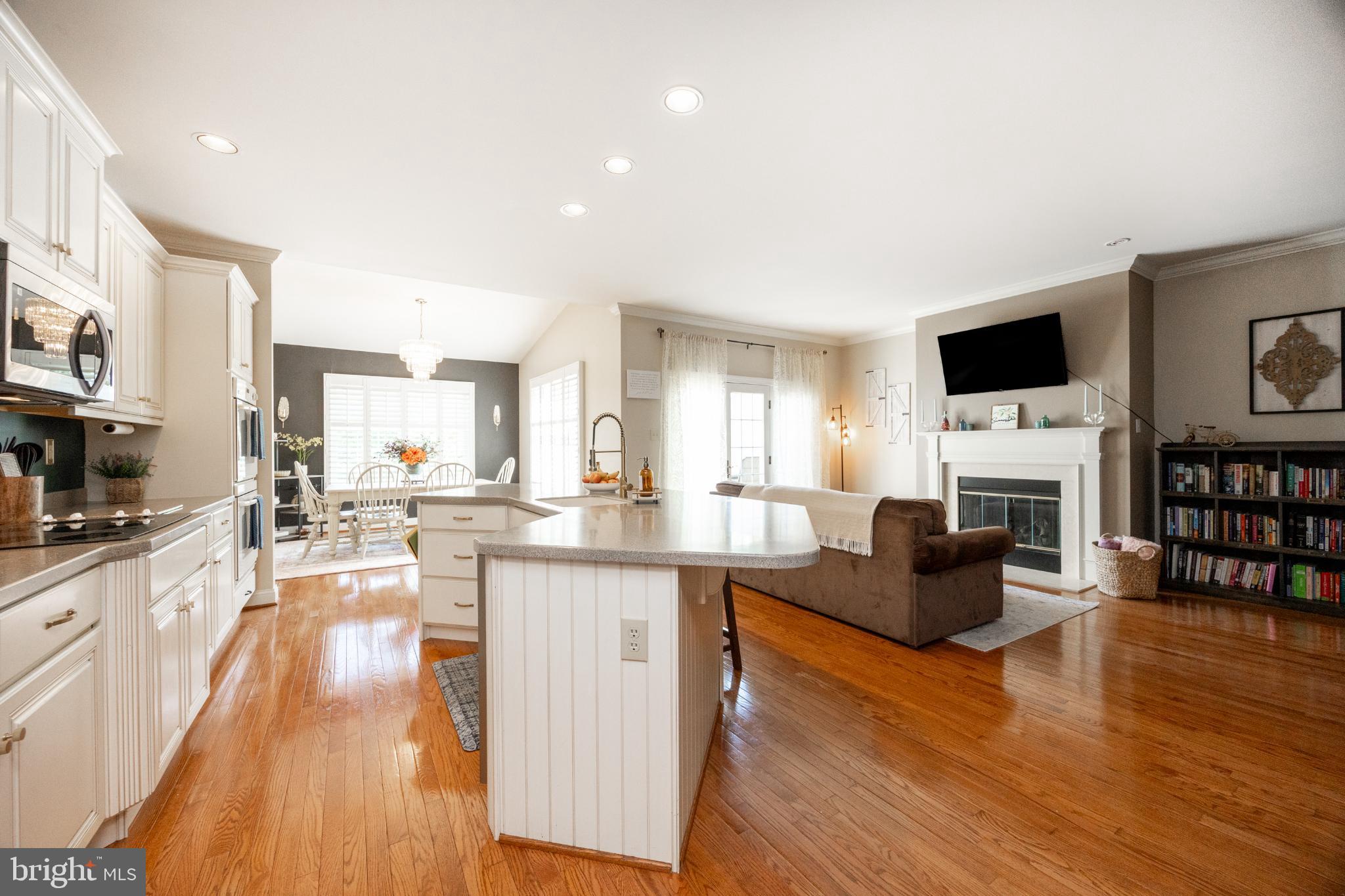 214 Windgate Drive Chester Springs, PA 19425 - Photo 11 of 45 a living room with furniture a fireplace a flat screen tv and a kitchen view