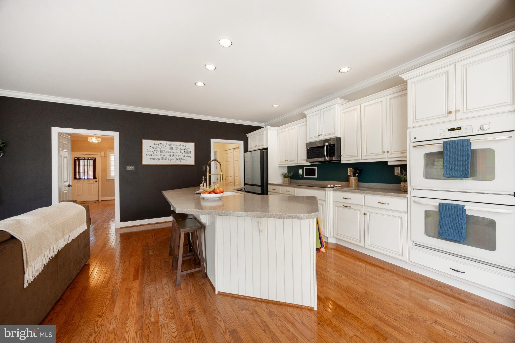 214 Windgate Drive Chester Springs, PA 19425 - Photo 15 of 45 a kitchen with stainless steel appliances granite countertop a stove top oven a sink dishwasher and white cabinets with wooden floor