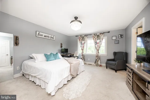 a bedroom with bed couch and window