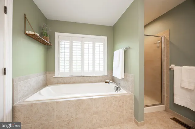 a white bath tub sitting in a bathroom next to a window