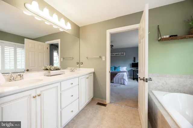 a en suite bathroom with a granite countertop sink and a mirror