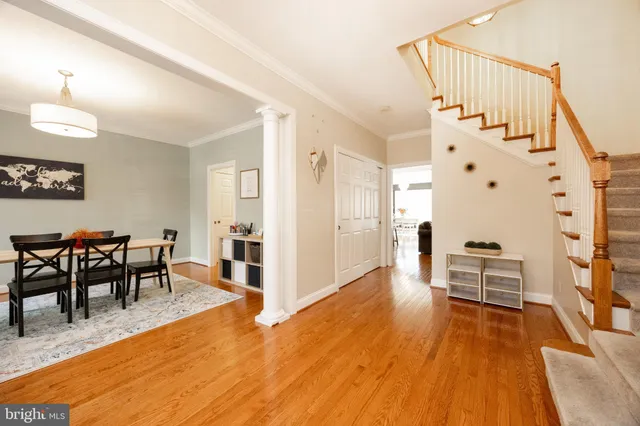 a dining room with wooden floor a chandelier a wooden table and chairs