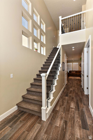 1622 Canyon Tree Drive St. George, UT 84770 - Photo 28 of 34 Two-story entryway featuring wood-finish flooring, a carpeted staircase with white newel posts, and wrought iron balusters