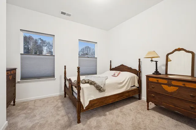 a bed sitting in a bedroom next to a window