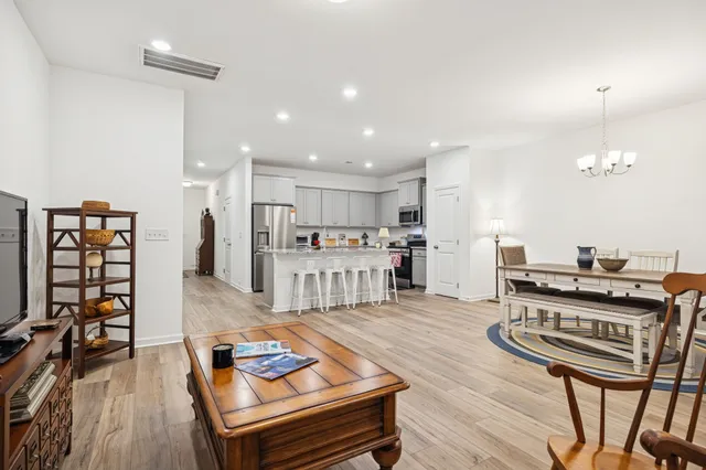 a room with a table chairs and entryway with wooden floor