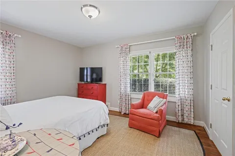 a bedroom with a bed and a couch next to a window