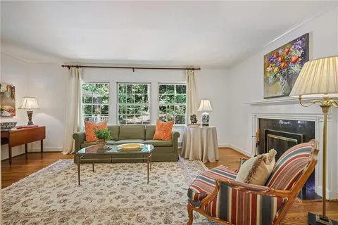 a living room with furniture a fireplace and a large window