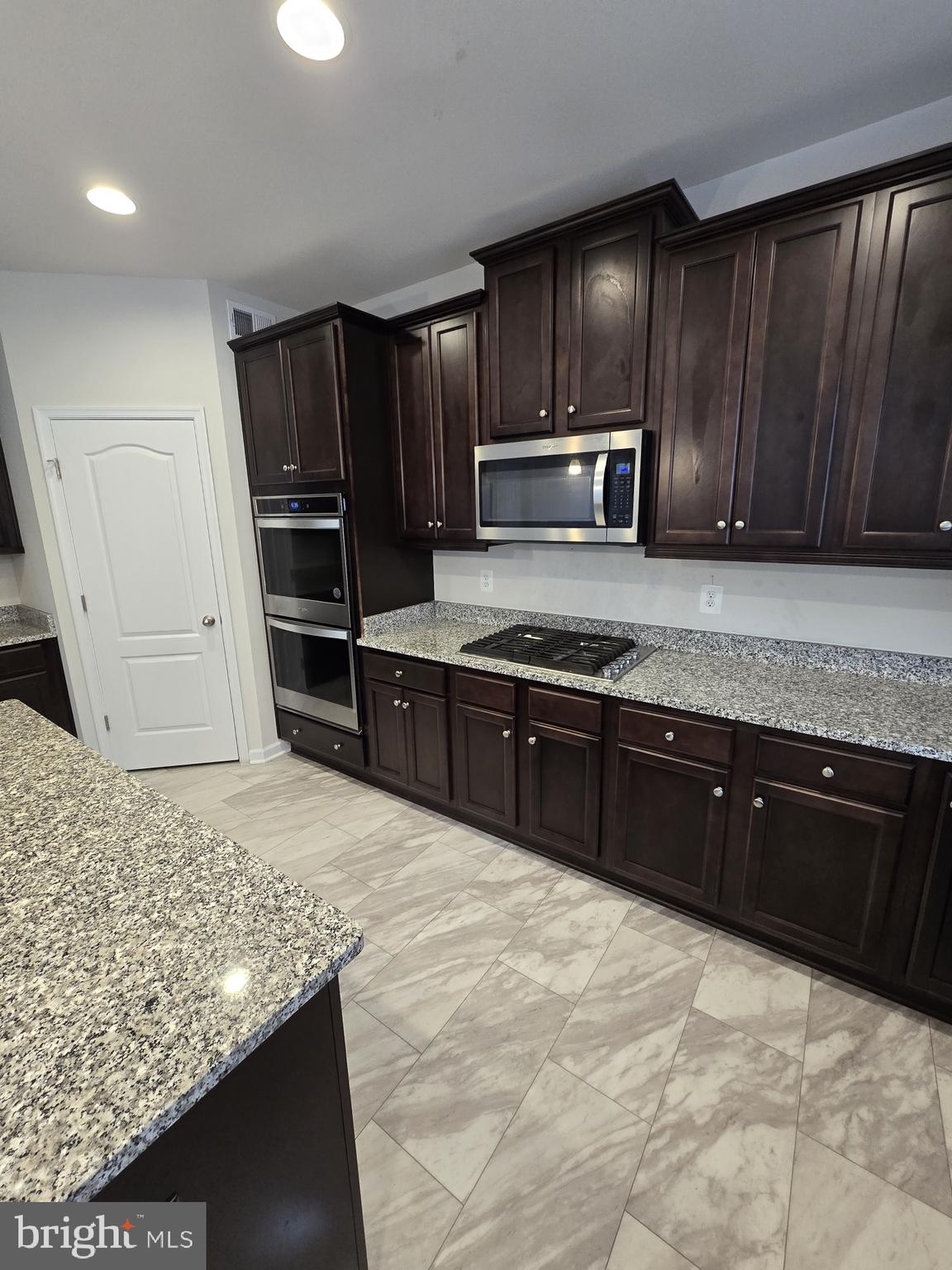 6592 Timber Ridge Lane Bryans Road, MD 20616 - Photo 12 of 60 a kitchen with stainless steel appliances granite countertop wooden cabinets a refrigerator and a sink