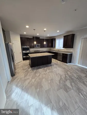 a kitchen with granite countertop wooden cabinets and refrigerator