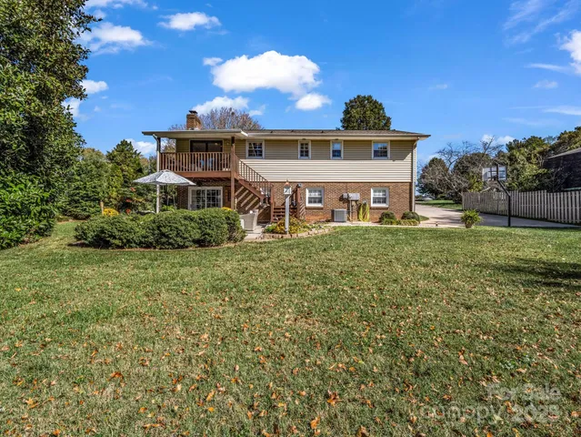 a view of a patio with table and chairs potted plants with wooden floor and fence