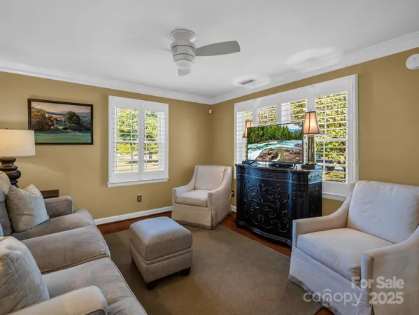 a living room with furniture kitchen view and a wooden floor