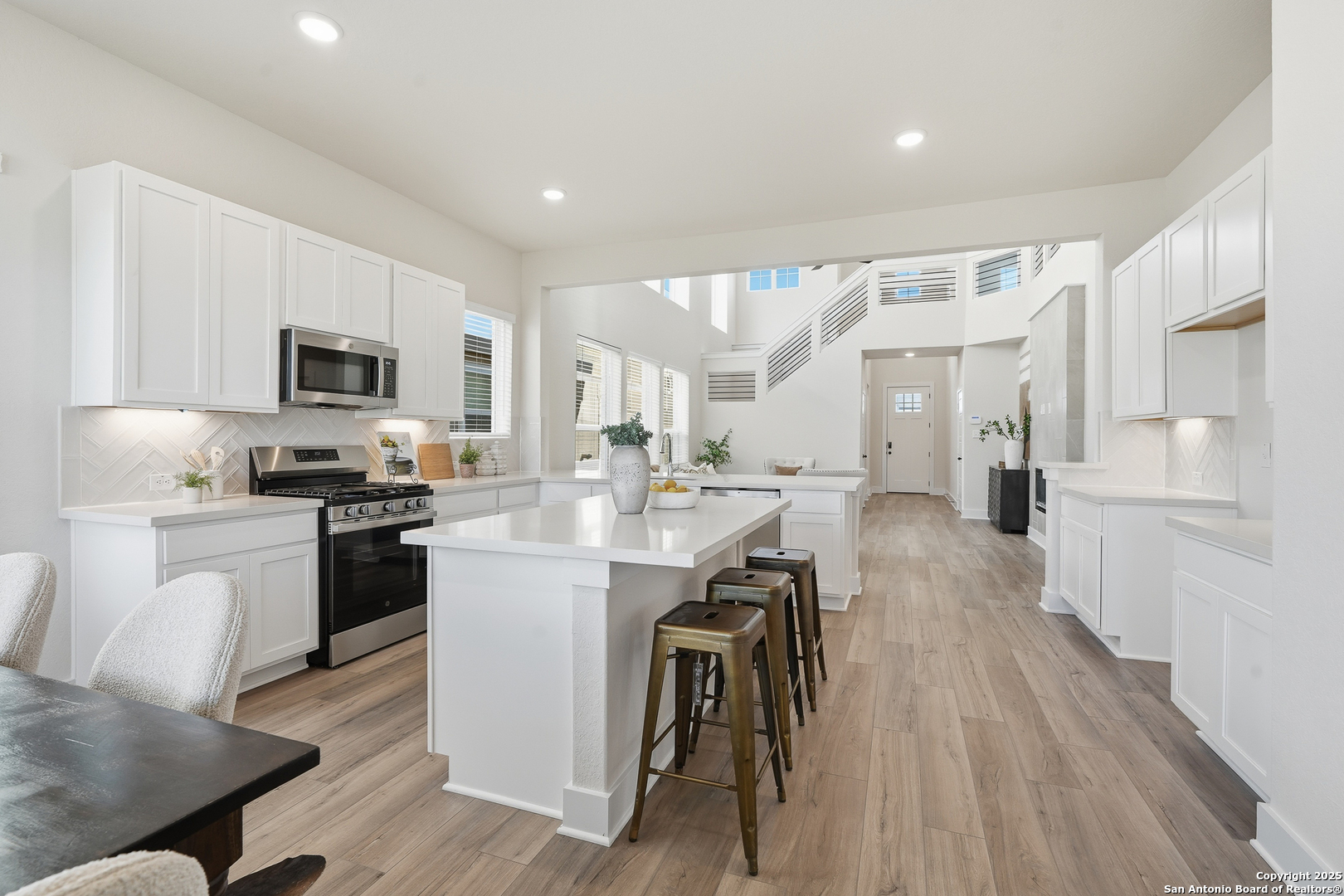 178 Jax Loop San Antonio, TX 78253 - Photo 11 of 45 a kitchen with stainless steel appliances granite countertop a refrigerator a stove top oven a sink dishwasher and white cabinets with wooden floor