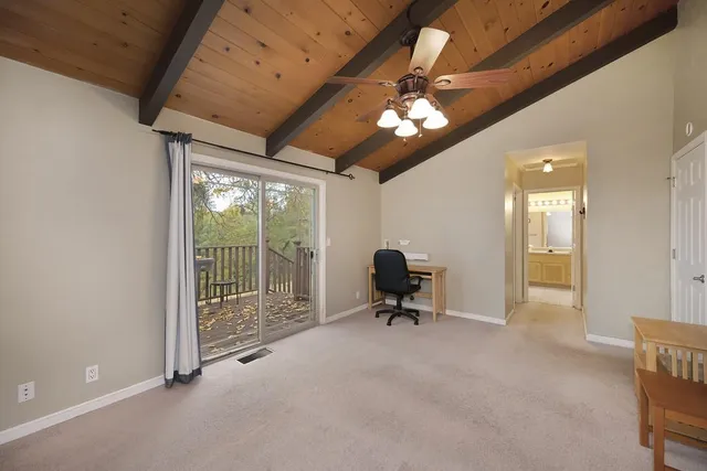 a balcony with wooden floor and trees in front of it
