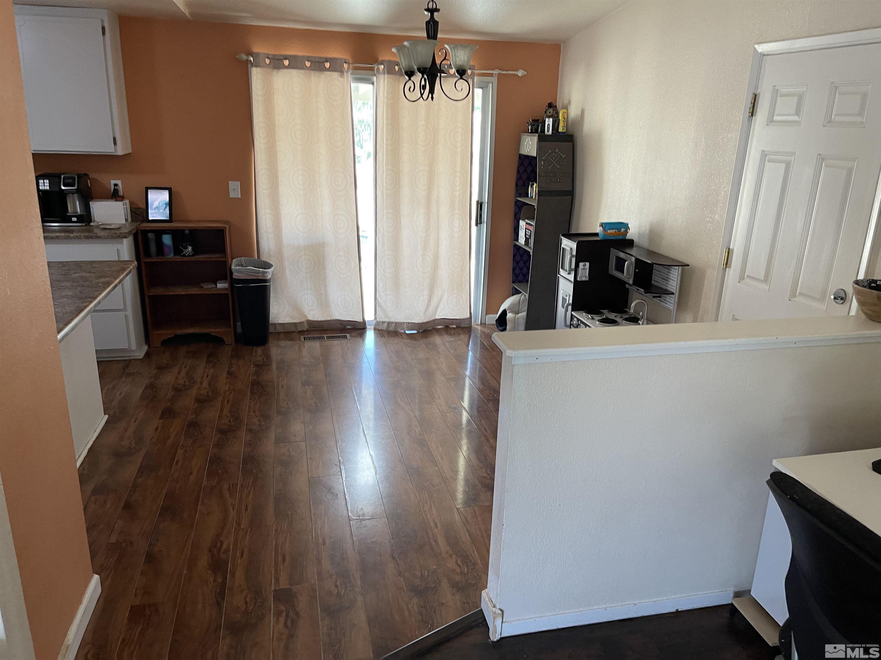 703 Empire Road Dayton, NV 89403 - Photo 6 of 31 a view of a kitchen with wooden floor and cabinets