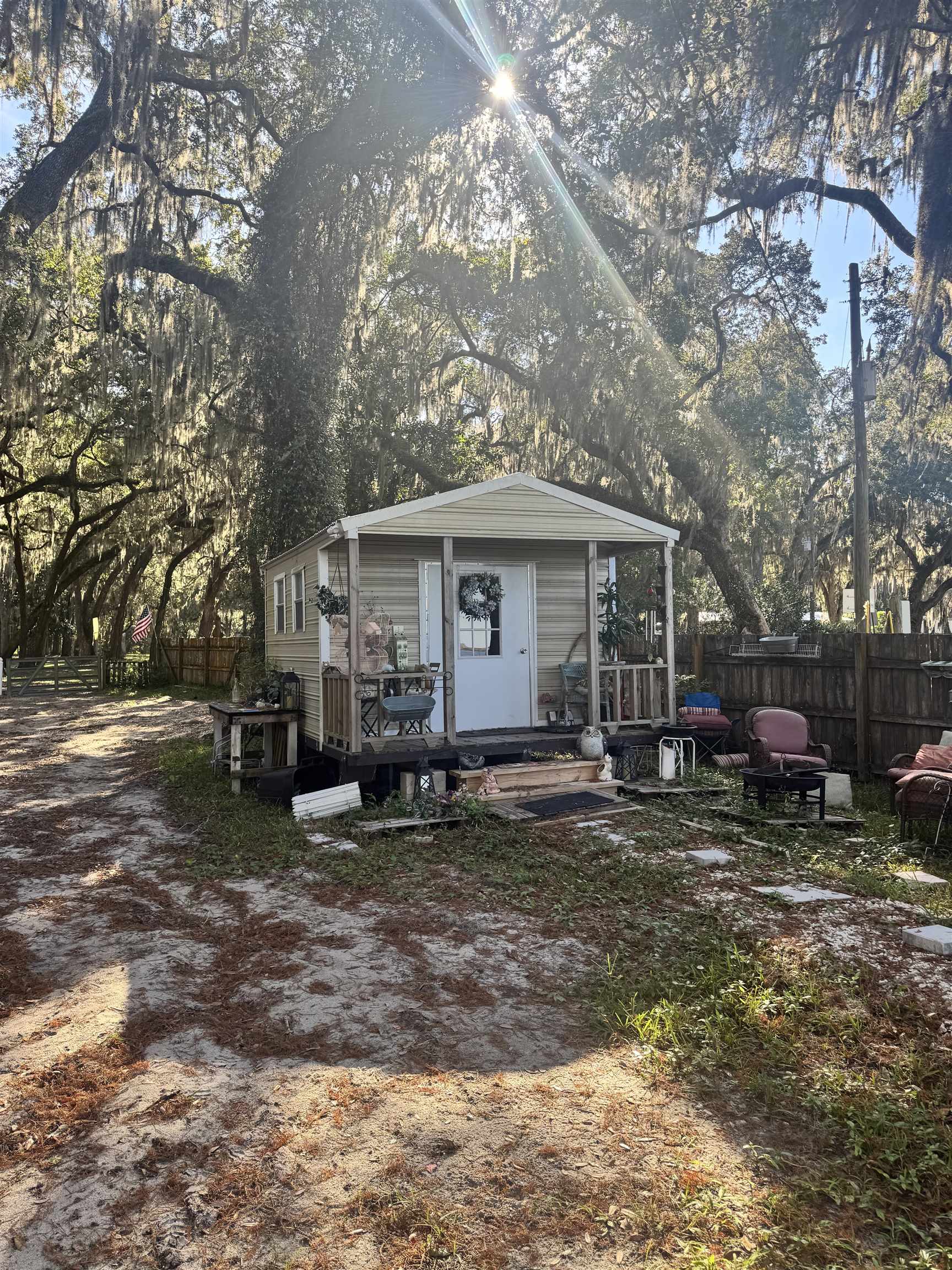 8550 Palmo Fish Camp Road, Unit 1 St. Augustine, FL 32092 - Photo 14 of 20 a view of a house with a yard chairs and a table under an umbrella