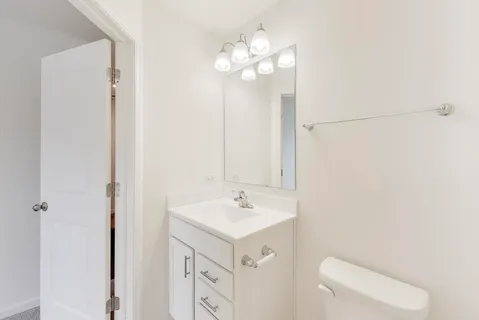 a bathroom with a sink a toilet and a mirror
