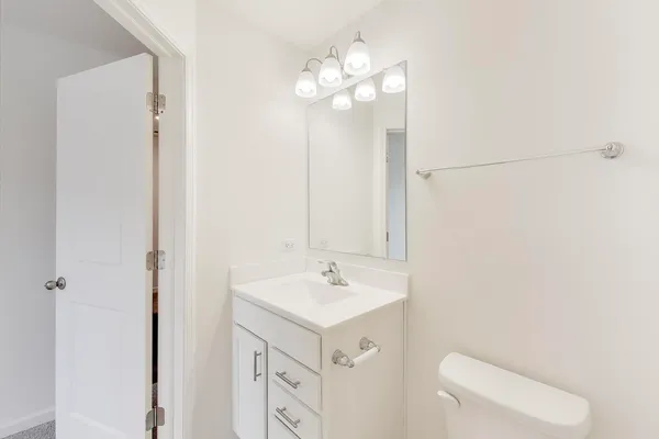 a bathroom with a sink a toilet and a mirror