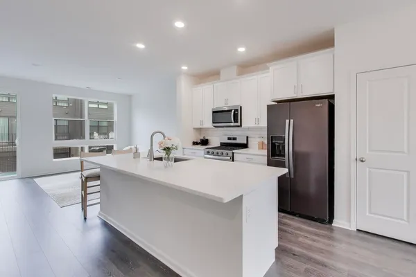 a large kitchen with kitchen island a sink stainless steel appliances and cabinets