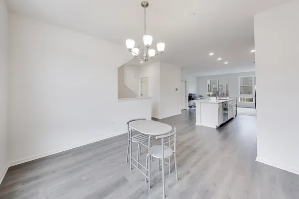 a living room with kitchen island furniture and a chandelier