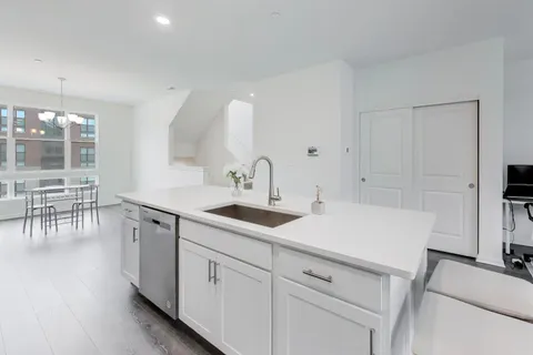 a kitchen with a sink cabinets and wooden floor