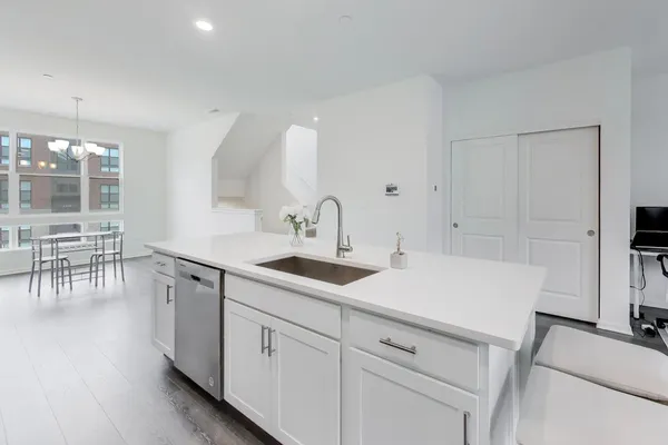 a kitchen with a sink cabinets and wooden floor