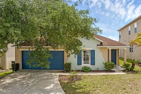 a front view of a house with garden and trees