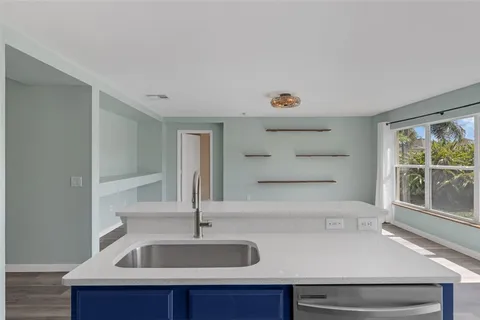 a view with kitchen island a sink appliances and a counter top space