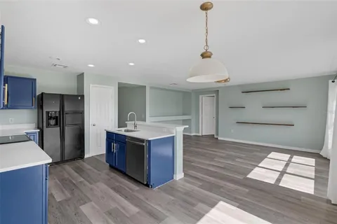 a kitchen with stainless steel appliances granite countertop a sink and a refrigerator