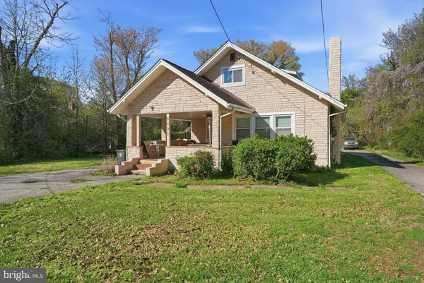 a front view of a house with a yard and trees