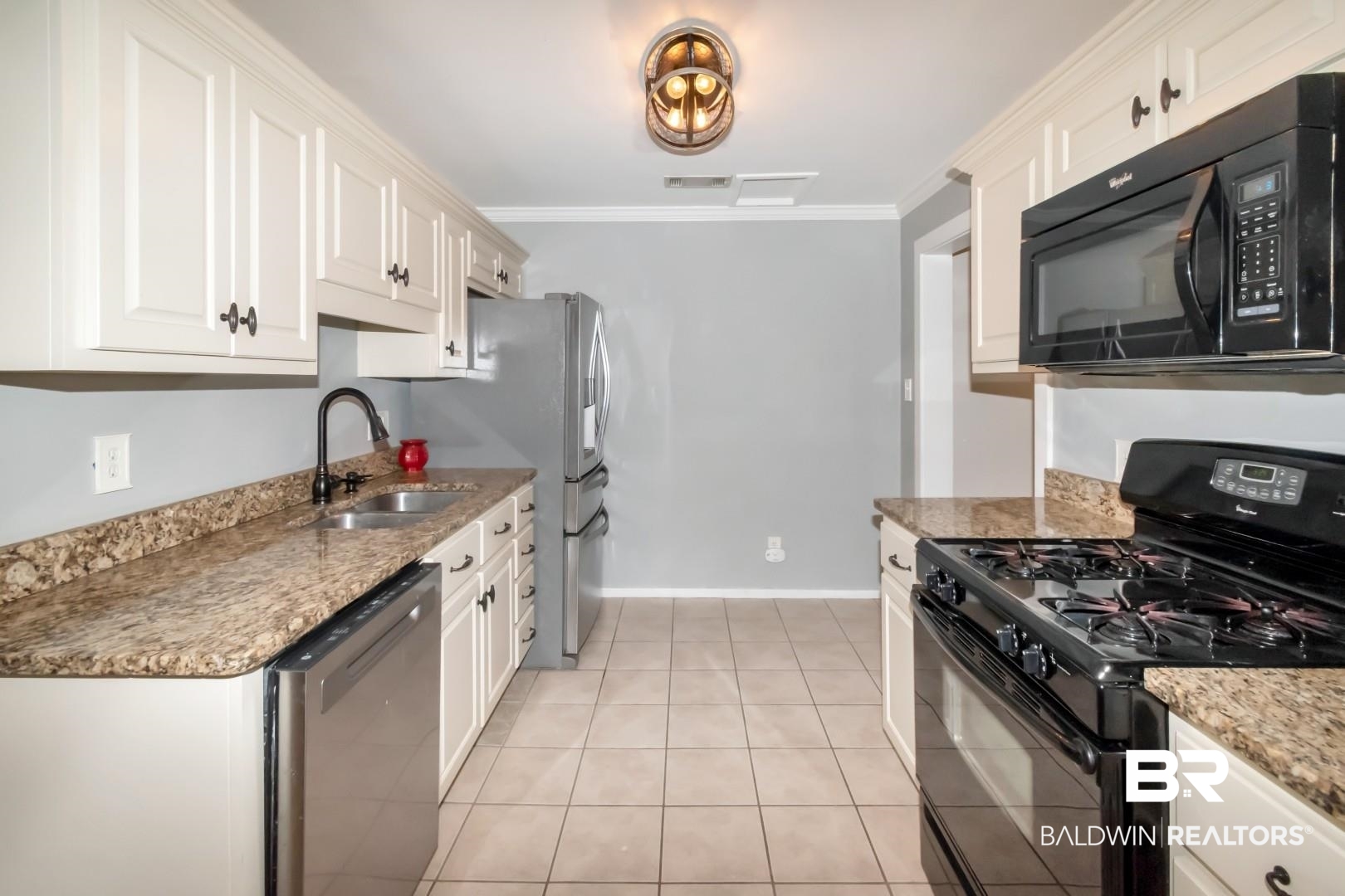 33 Lancaster Road Mobile, AL 36608 - Photo 12 of 40 Kitchen featuring black appliances, a sink, white cabinetry, light tile patterned floors, and crown molding