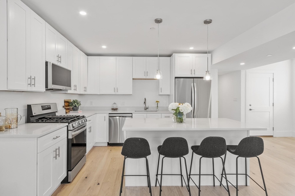 79 Maple Street, Unit 3 Boston, MA 02136 - Photo 2 of 13 a kitchen with a sink cabinets and chairs