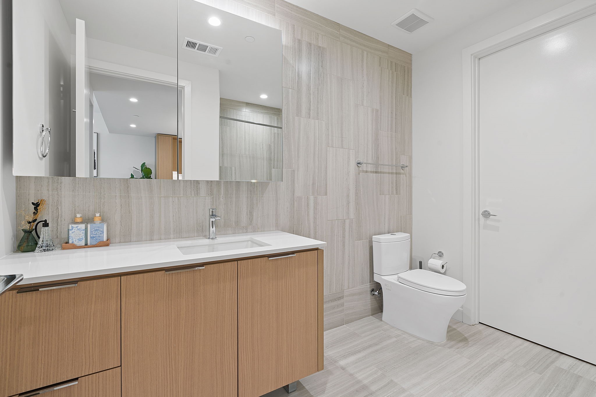 44 East Avenue, Unit 1902 Austin, TX 78701 - Photo 17 of 40 a bathroom with a granite countertop sink a toilet and a mirror