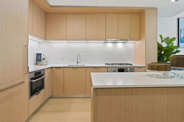 a kitchen with granite countertop a refrigerator a stove a sink and dishwasher