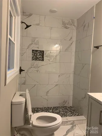 a bathroom with a toilet and a shower